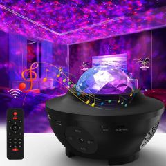 Galaxy projector on a table in a purple room with the remote beside it